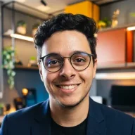 Foto de Mateus Alves, sorrindo, de óculos e blazer azul